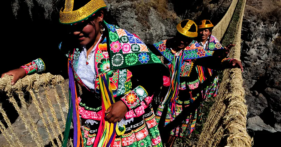 Local women crossing the Qeswachaka bridge in traditional costume