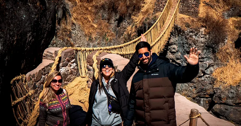 Tourists on the Qeswachaka Bridge smiling and enjoying themselves