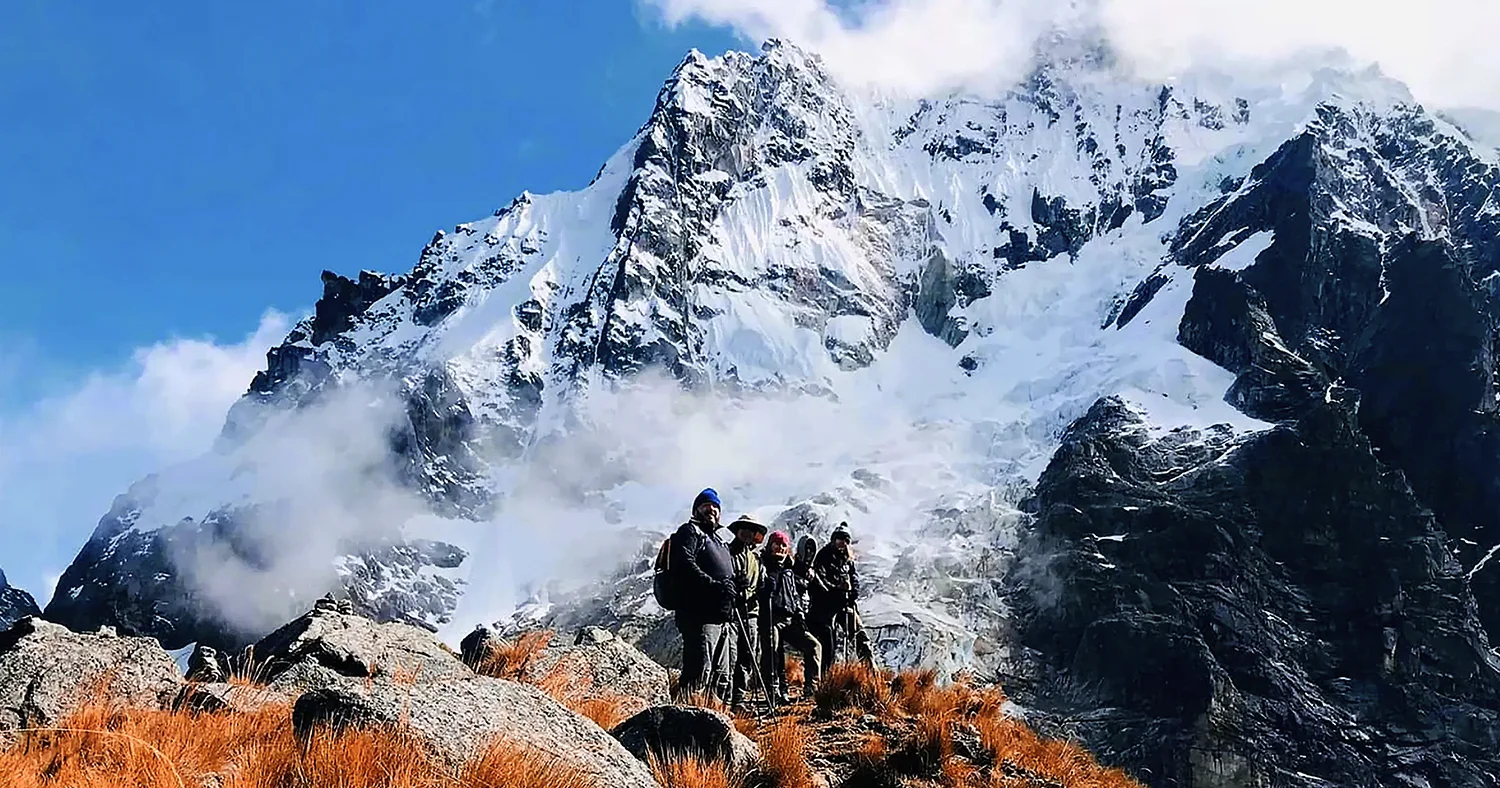 Hikers on the Salkantay Trek surrounded by snow-covered Andean mountains