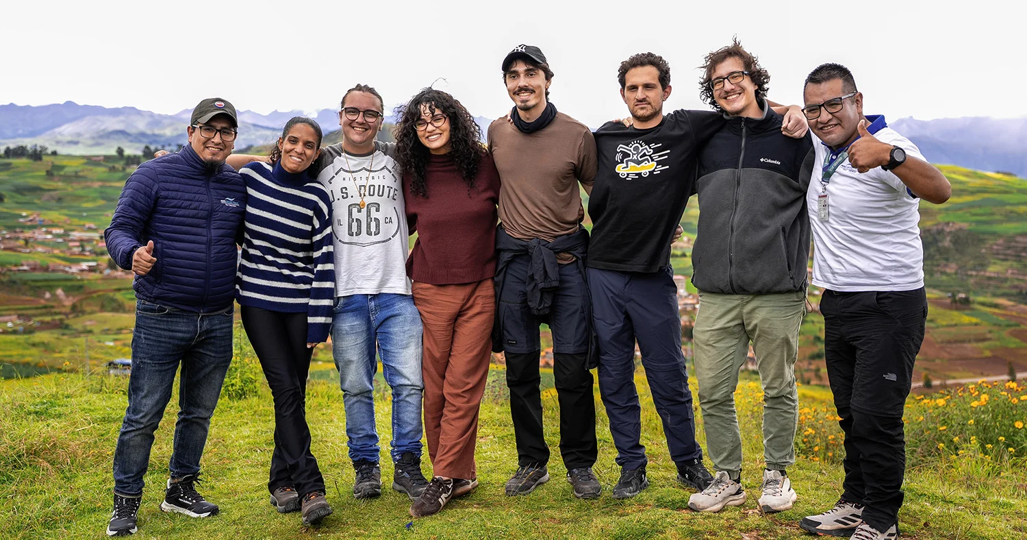Group of travelers posing together with local guides in the Sacred Valley near Cusco, Peru