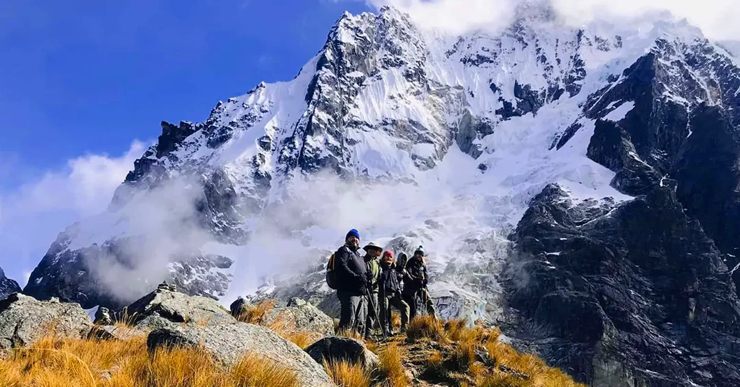 Hikers walking toward snow-covered mountains on the Salkantay Trek in Peru