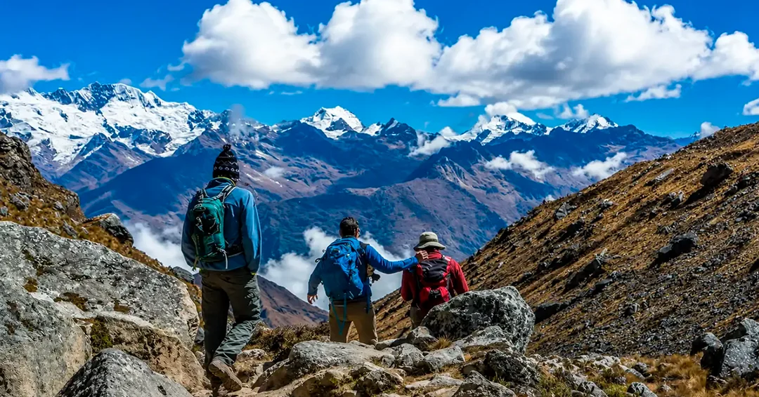 Group of hikers standing beneath a snow-covered Andean mountain on the Salkantay Trek