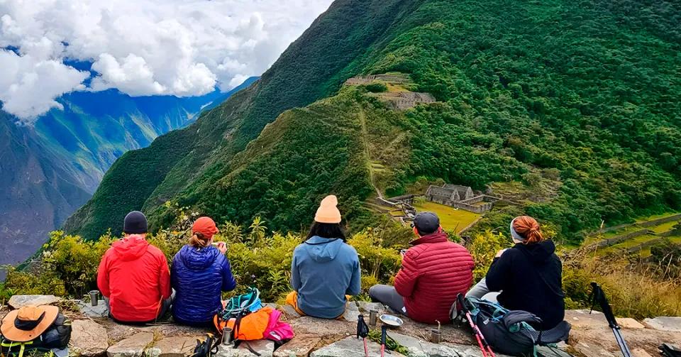 Hikers resting on a ridge with a panoramic view of the deep canyon on the Choquequirao Trek.