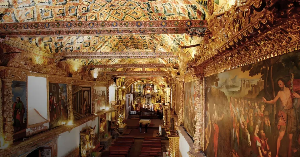 Ornate interior of Andahuaylillas Church in Cusco, Peru, featuring religious murals and a decorated ceiling Ornate interior of Andahuaylillas Church in Cusco, Peru, featuring religious murals and a decorated ceiling