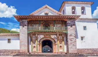 Colonial facade of Andahuaylillas Church with painted decorations and a bell tower in Cusco, Peru
