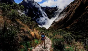 Hiker walking through the Andean landscape on the Salkantay Trek
