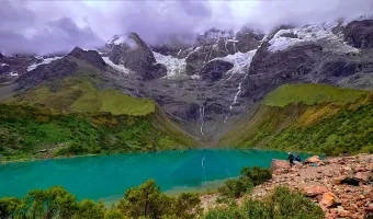 Hikers descending a mountain trail with panoramic views of the Peruvian Andes