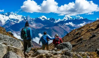 Group of hikers standing beneath a snow-covered Andean mountain on the Salkantay Trek