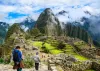 Travelers exploring the Inca ruins and mountain landscape of Machu Picchu in Peru